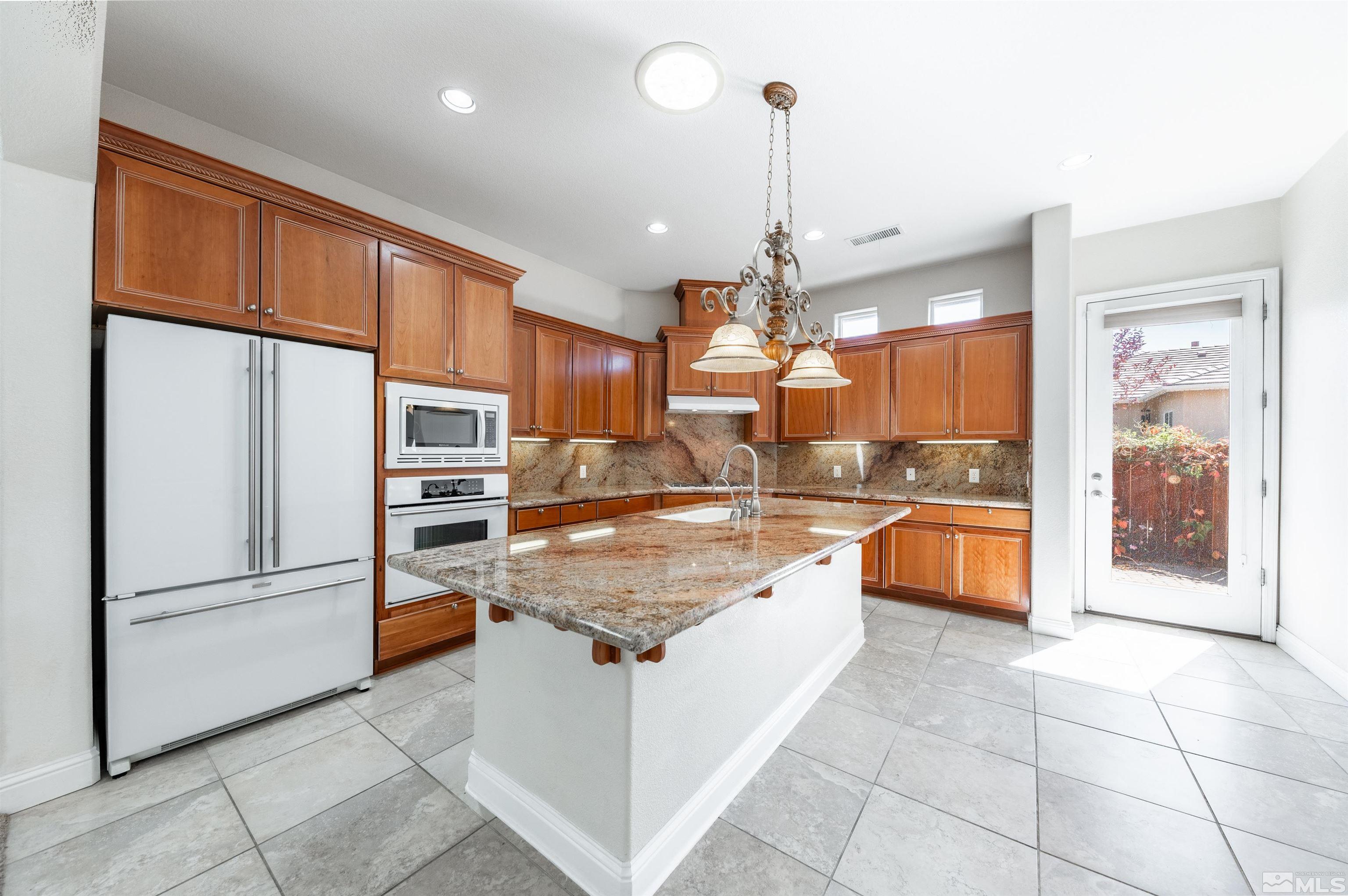 985 Bella Monte Drive Minden, NV 89423 - Photo 11 of 37 a large kitchen with granite countertop a large counter top stainless steel appliances and cabinets
