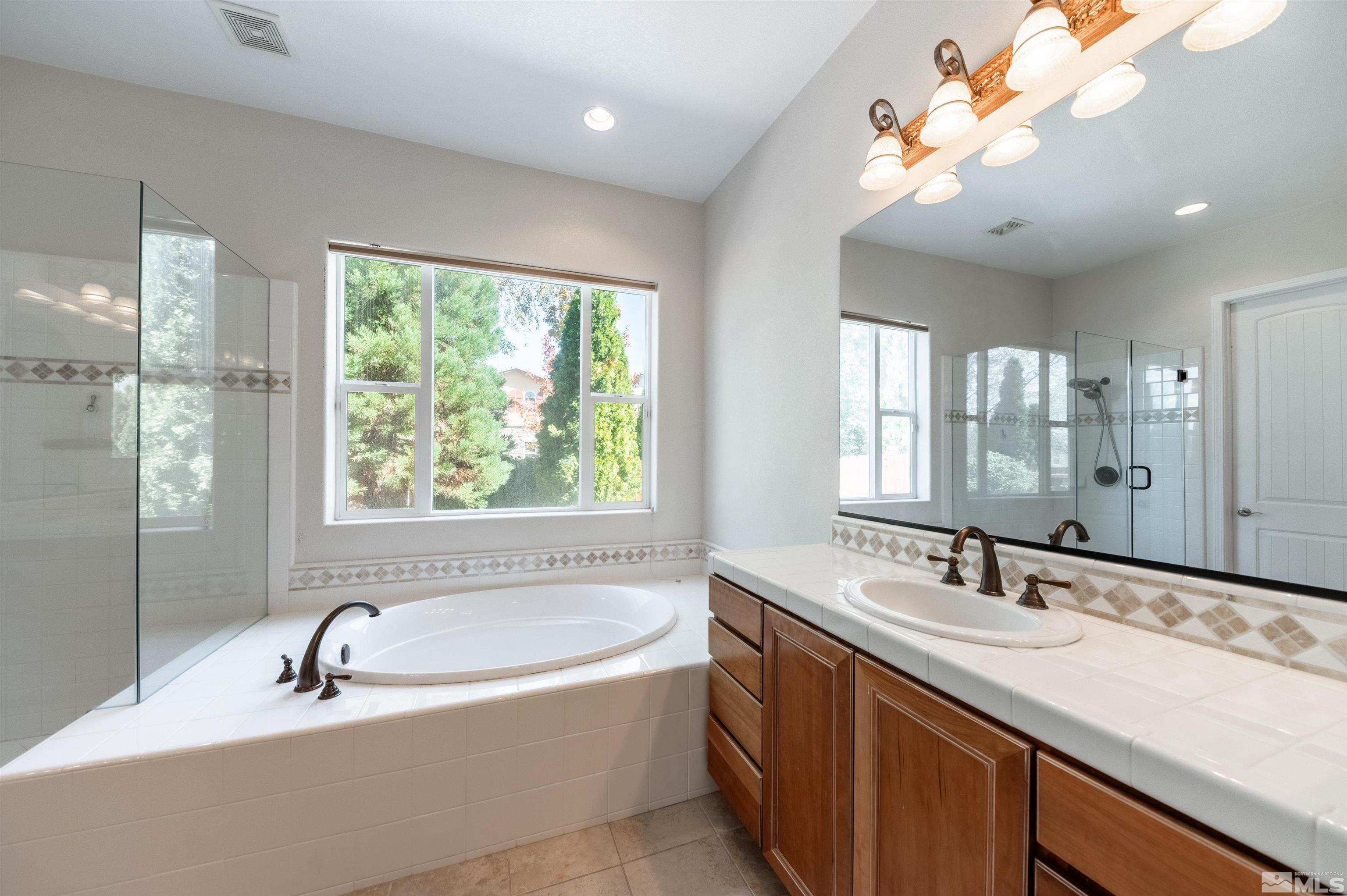 985 Bella Monte Drive Minden, NV 89423 - Photo 16 of 37 a bathroom with a granite countertop sink mirror and bathtub