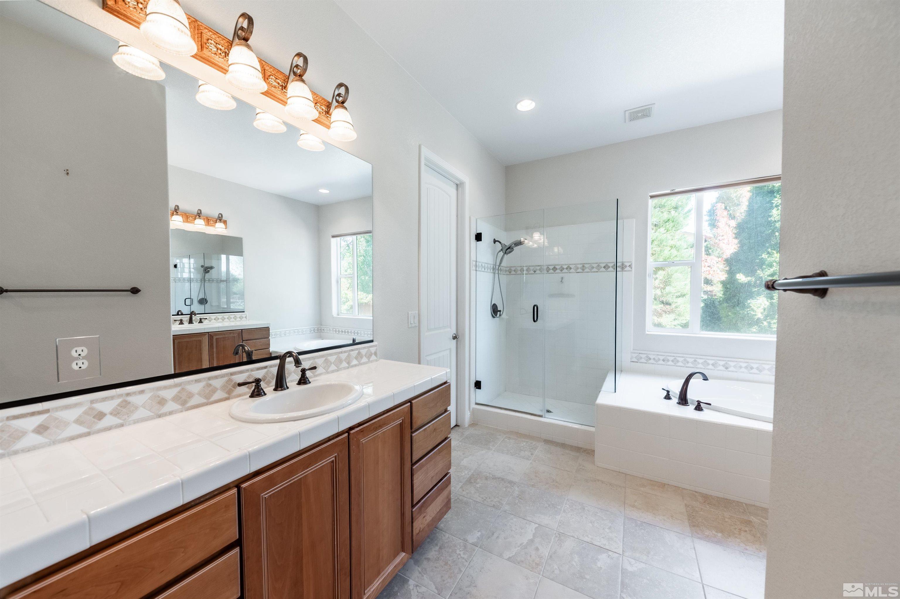 985 Bella Monte Drive Minden, NV 89423 - Photo 18 of 37 a bathroom with a tub a sink double vanity and a mirror