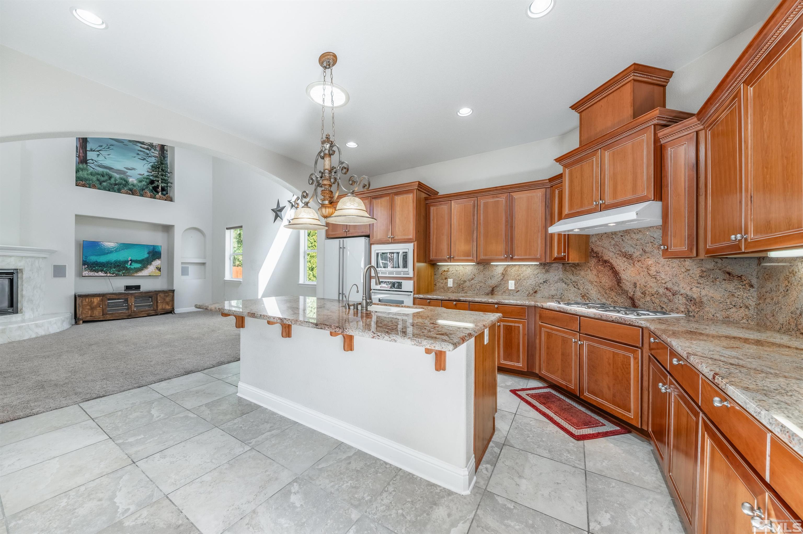 985 Bella Monte Drive Minden, NV 89423 - Photo 10 of 37 a large kitchen with kitchen island granite countertop a sink dishwasher a stove and a refrigerator with wooden floor