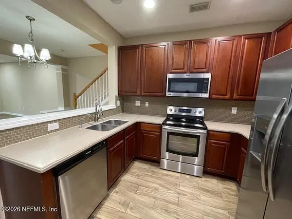 a kitchen with stainless steel appliances granite countertop a refrigerator sink and cabinets