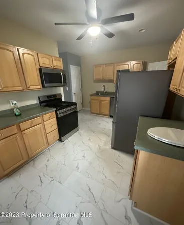 a kitchen with stainless steel appliances a refrigerator sink and microwave