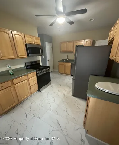 a kitchen with stainless steel appliances a refrigerator sink and microwave