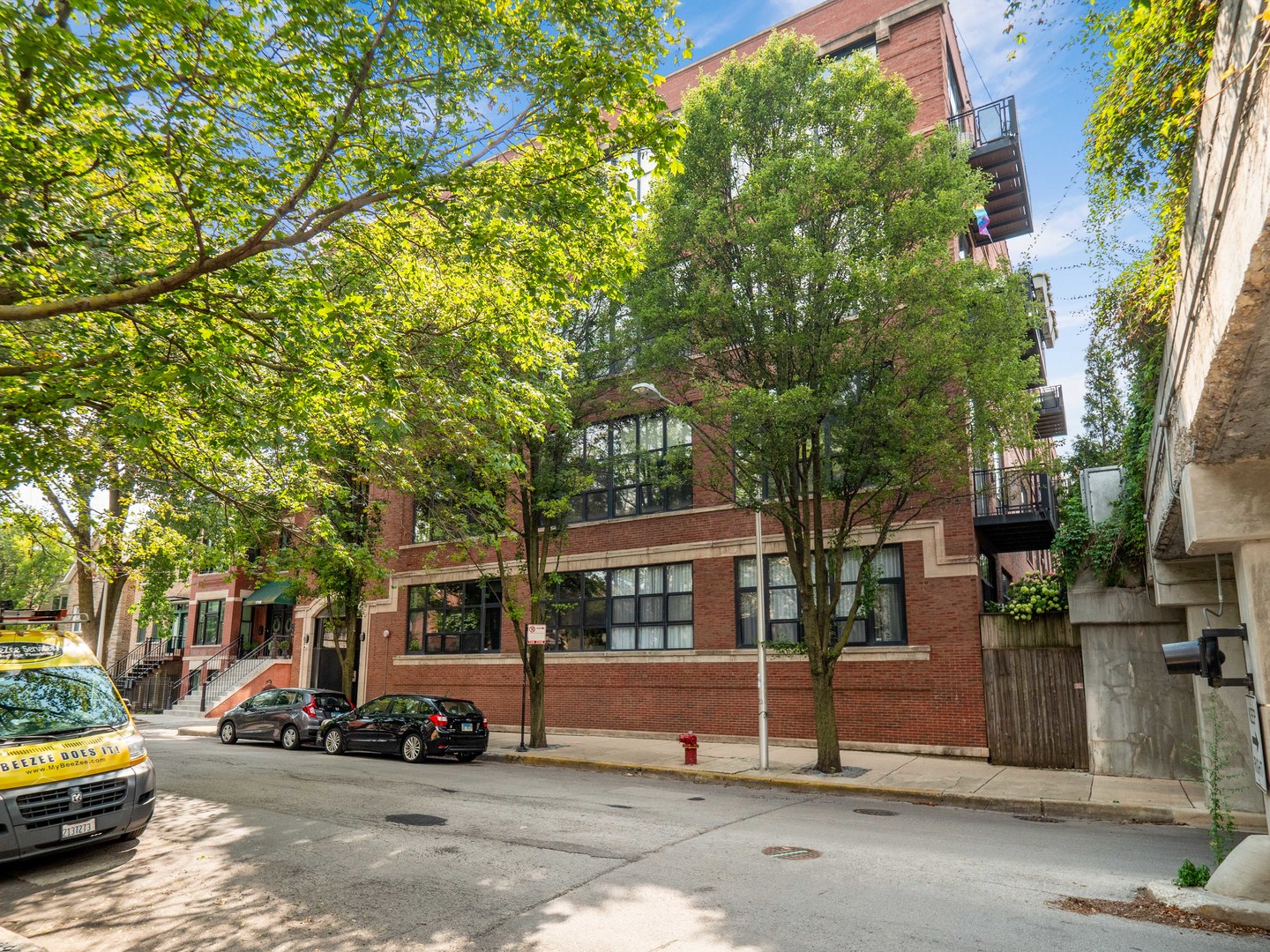 a view of a house with a large tree and many windows