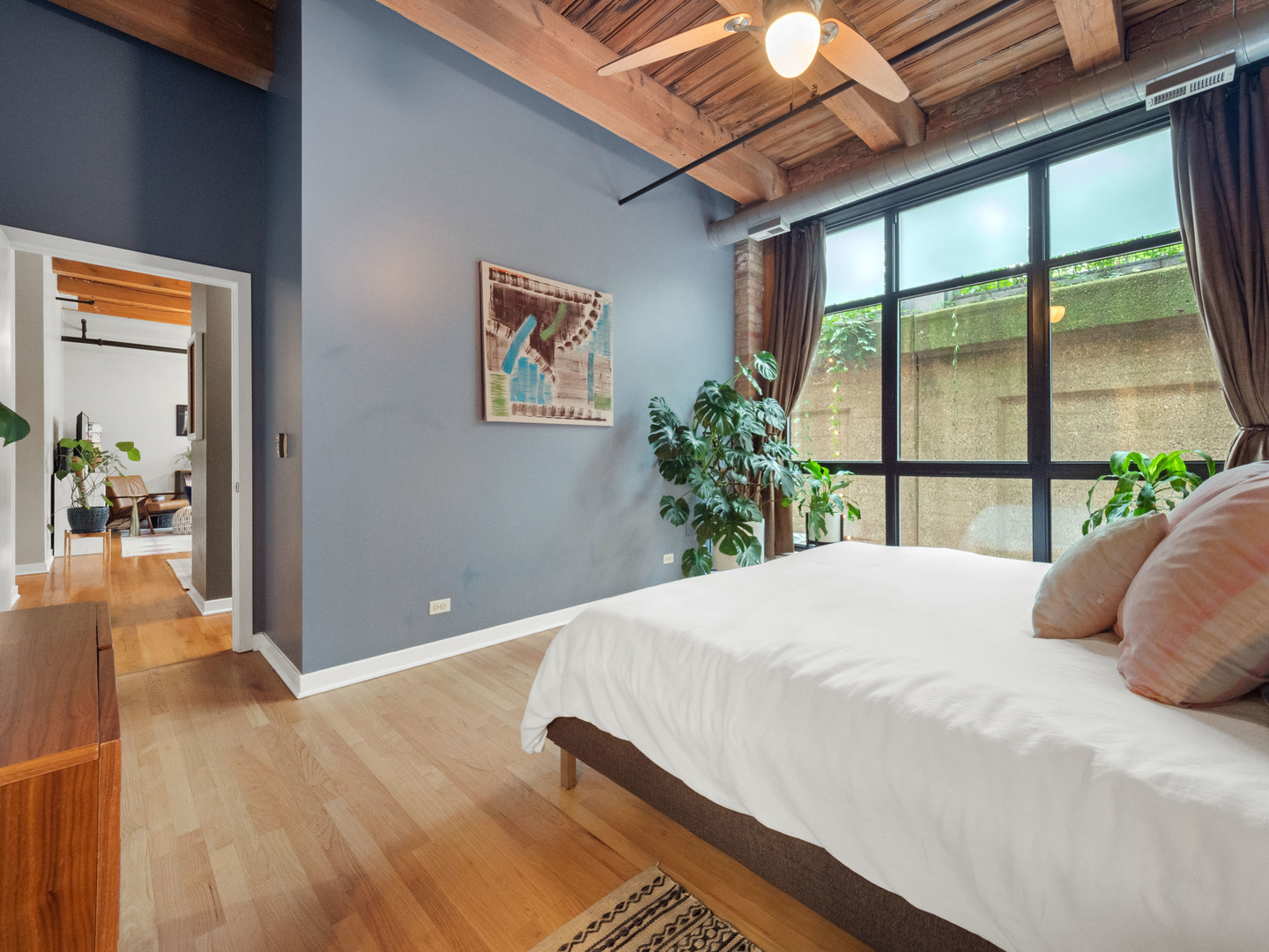 1750 North Wolcott Avenue, Unit 104 Chicago, IL 60622 - Photo 19 of 32 a bedroom with a bed and a large window