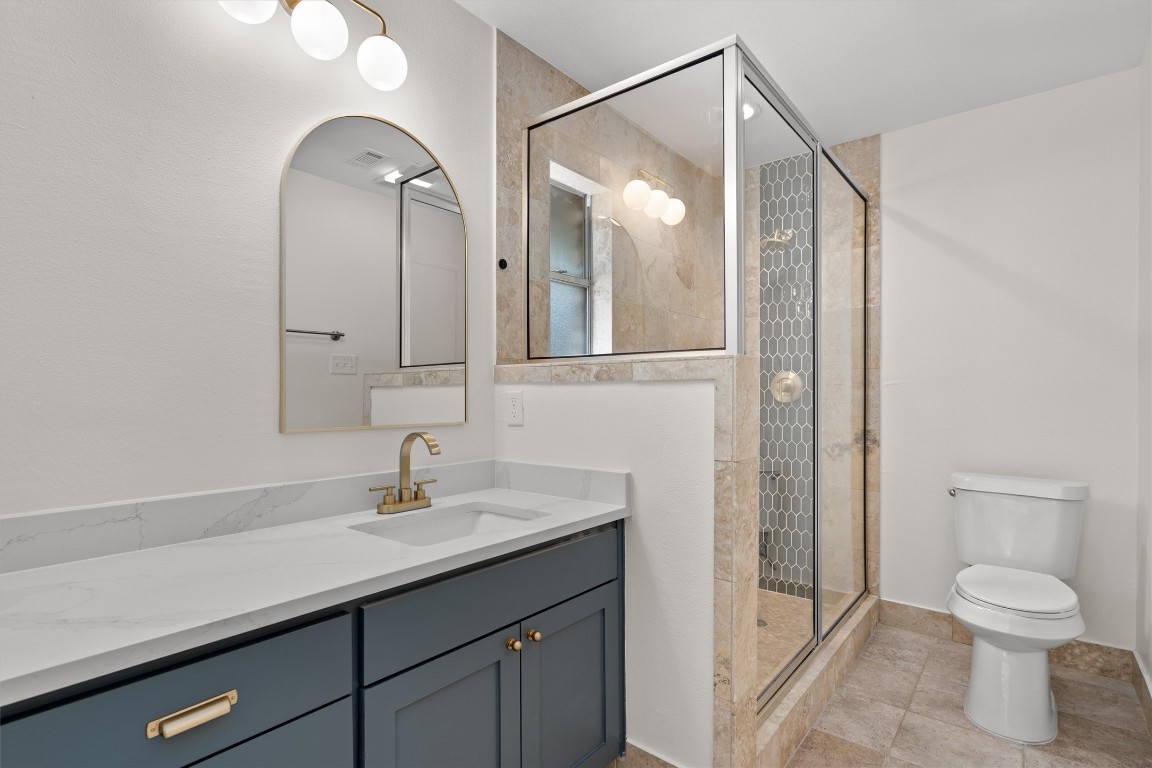 7008 Beckett Road Austin, TX 78749 - Photo 14 of 23 Bathroom featuring a stall shower, vanity, and light tile patterned floors