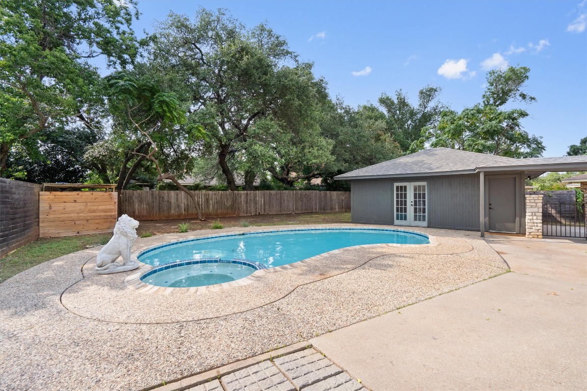 7008 Beckett Road Austin, TX 78749 - Photo 22 of 23 View of swimming pool with a fenced backyard, a pool with connected hot tub, french doors, and a patio
