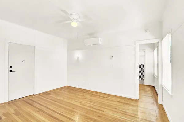 a view of empty room with wooden floor