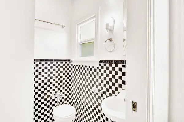a bathroom with a black white checkered floor