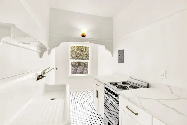 a kitchen with a stove a sink and a window