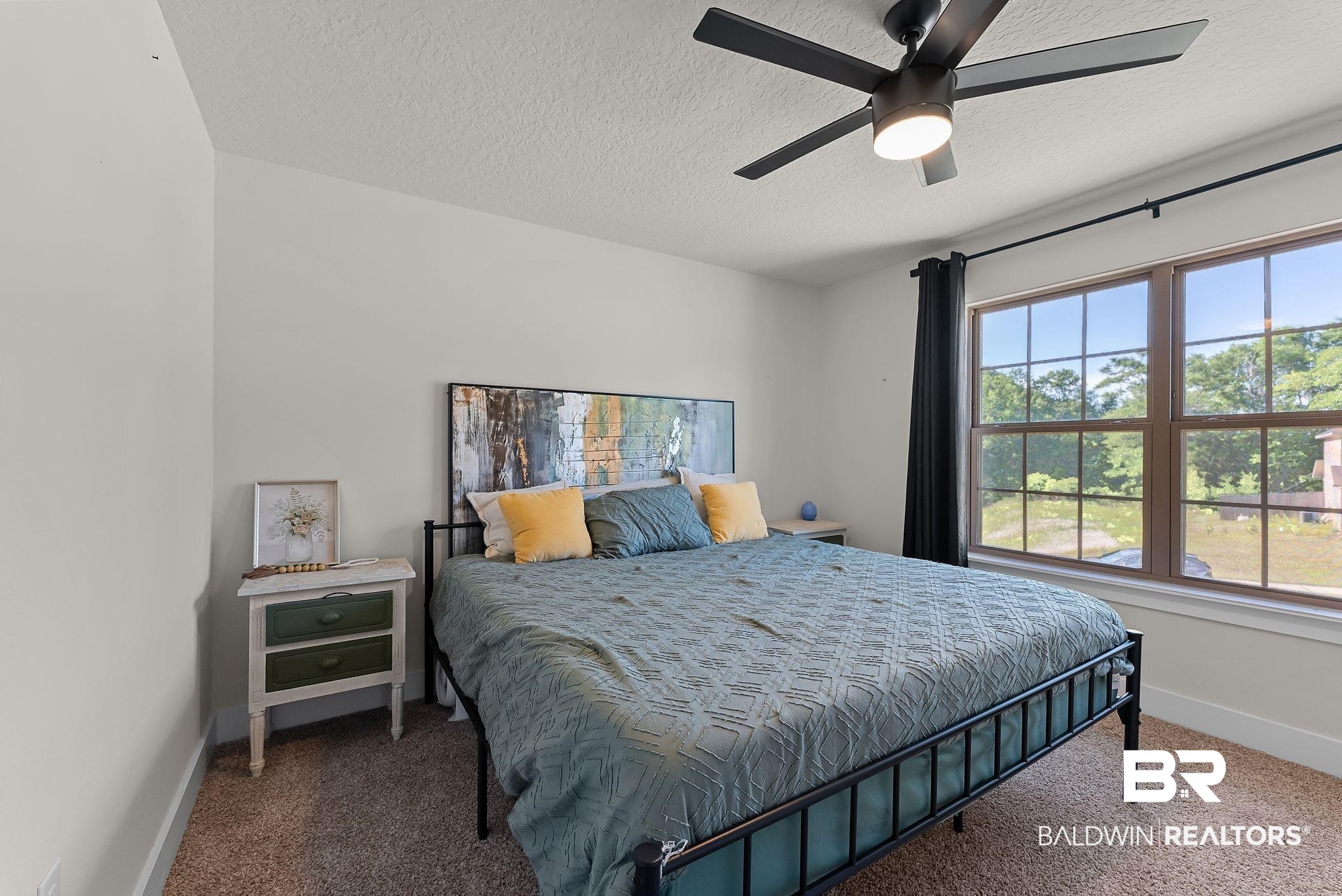 16607 Prado Loop Loxley, AL 36551 - Photo 23 of 46 Bedroom featuring a large window with multiple panes, a ceiling fan with integrated lighting, and neutral wall tones