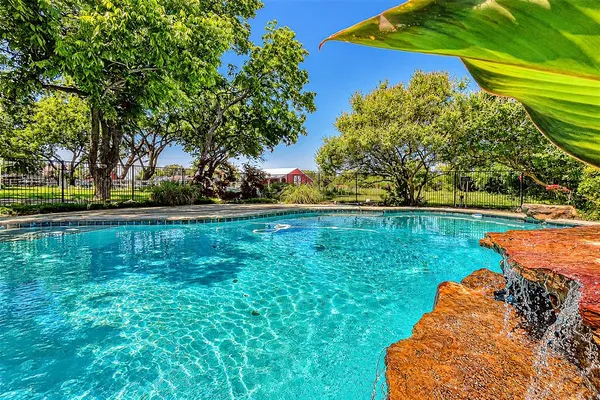 a backyard of a house with lots of green space and fountain