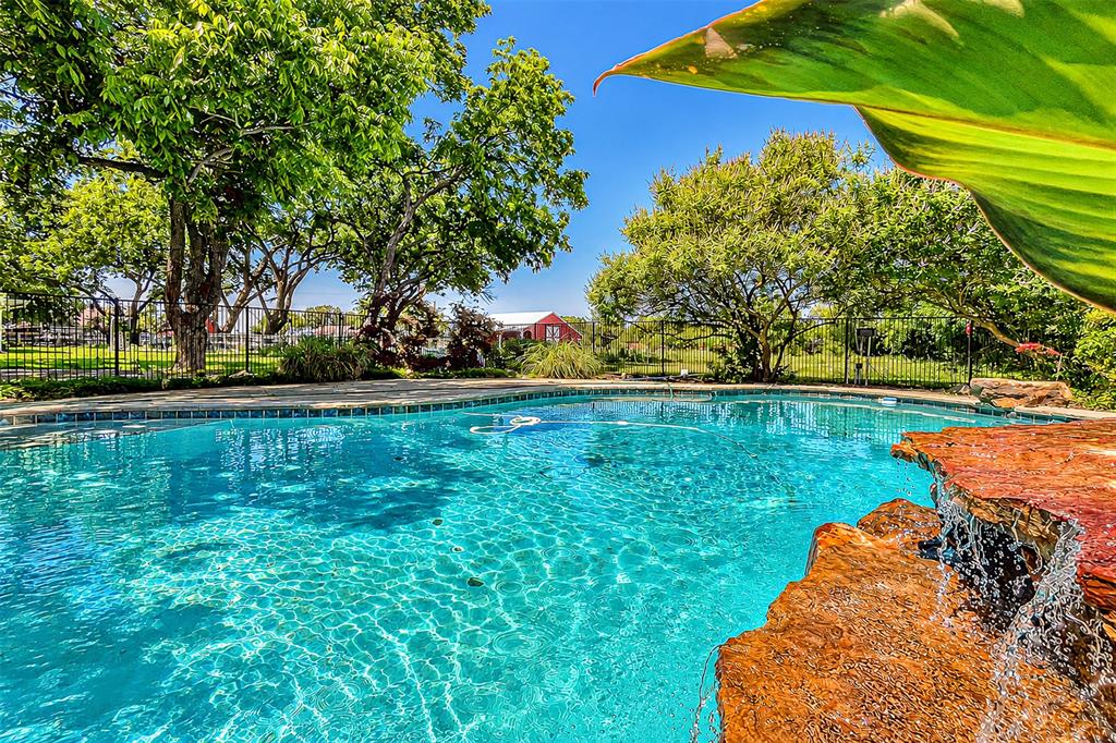 a backyard of a house with lots of green space and fountain