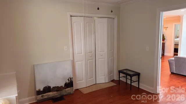 a dining room with wooden floor a chandelier a wooden table and chairs