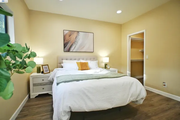 a bedroom with a bed and a painting on the wall