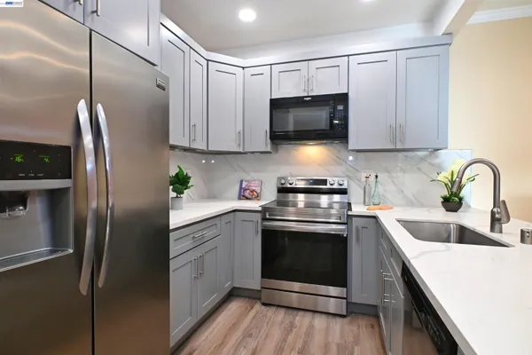 a kitchen with stainless steel appliances cabinets a sink and a microwave
