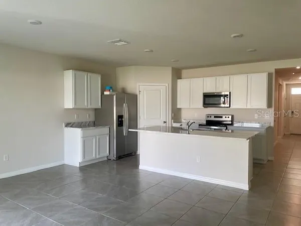 a kitchen with stainless steel appliances a refrigerator sink stove microwave and cabinets