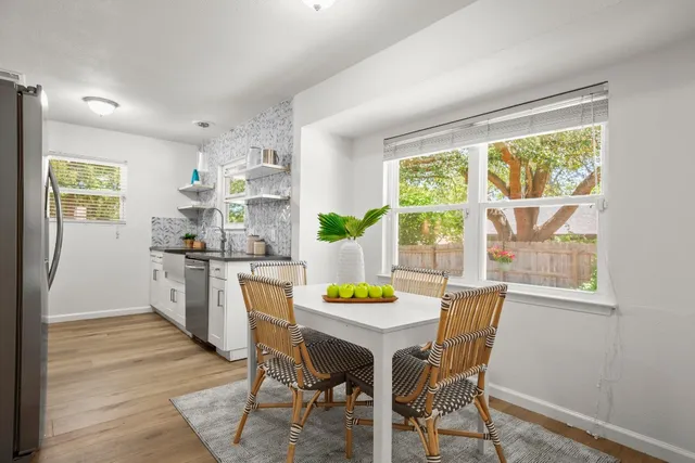 a kitchen with a table chairs and a window