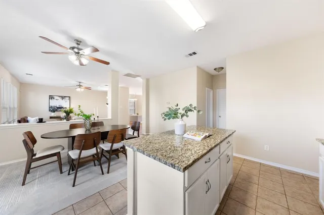 a view of kitchen island with cabinets table and chairs