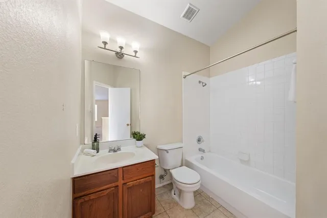 a bathroom with a toilet a sink a mirror a bathtub and vanity