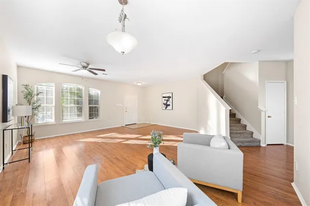 a living room with furniture and a wooden floor