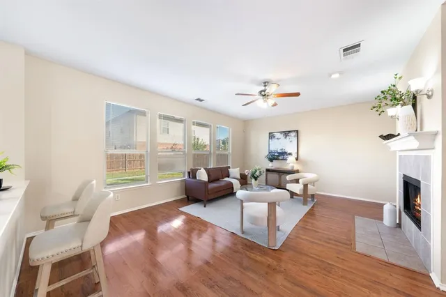 a living room with furniture a fireplace and a large window