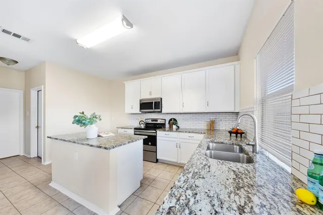 a kitchen with a sink stove and cabinets