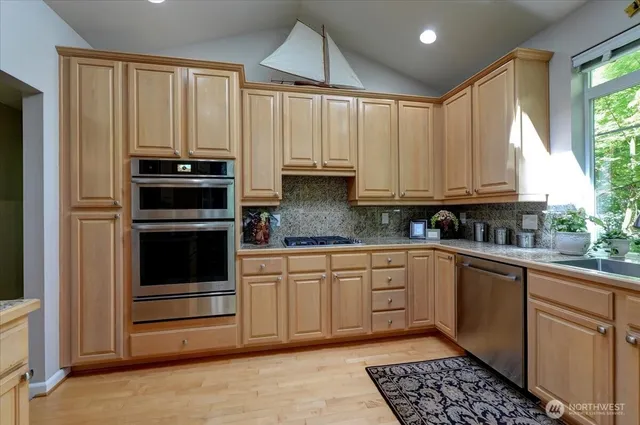 a kitchen with stainless steel appliances granite countertop a refrigerator and a sink