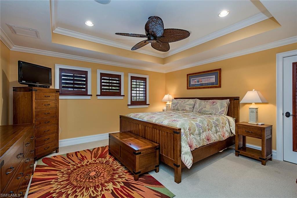 85 13th Avenue South Naples, FL 34102 - Photo 11 of 13 a spacious bedroom with a bed and a tv
