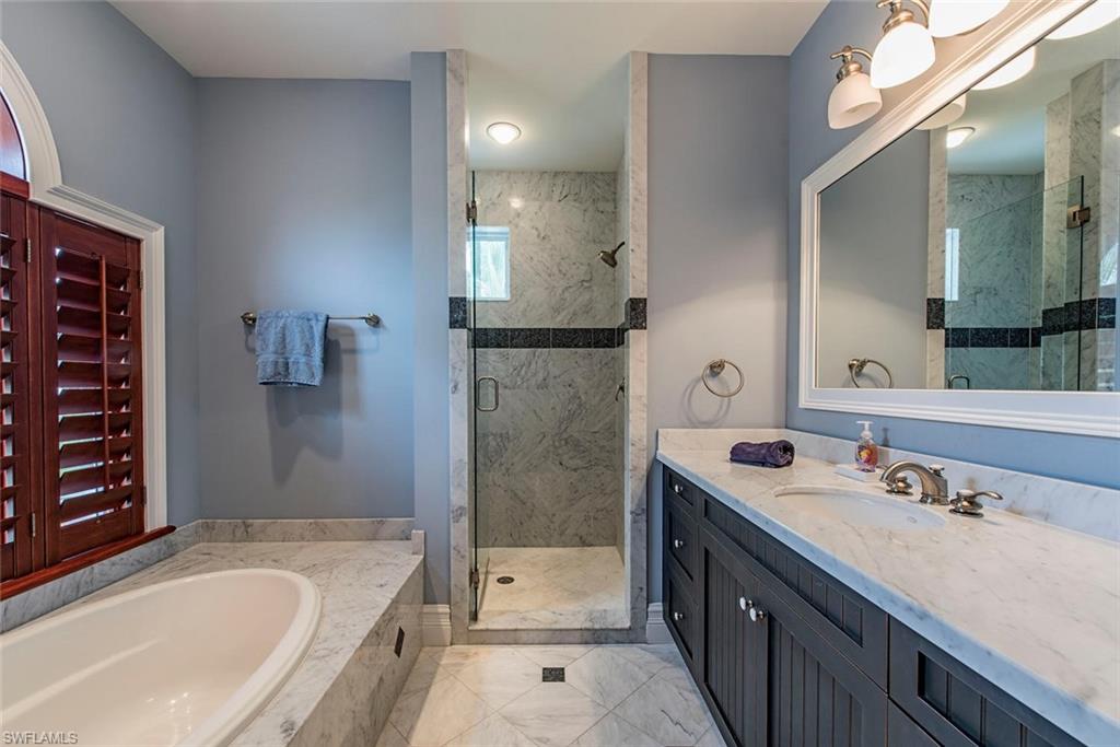 85 13th Avenue South Naples, FL 34102 - Photo 12 of 13 a bathroom with a tub sink and mirror