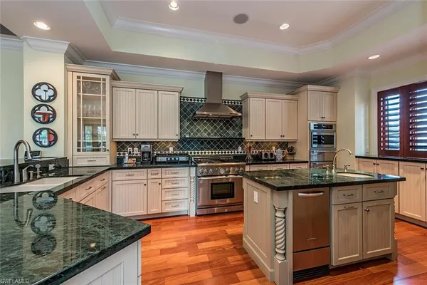a kitchen with stainless steel appliances granite countertop a sink stove and cabinets
