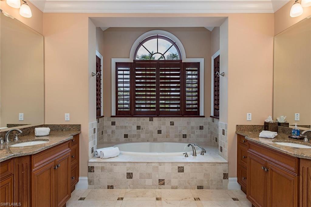 85 13th Avenue South Naples, FL 34102 - Photo 8 of 13 a bathroom with a bathtub and a sink