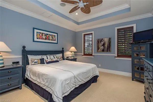 a bedroom with bed tv and window