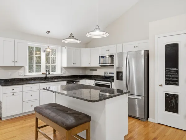 a kitchen with stainless steel appliances granite countertop a stove refrigerator sink and microwave