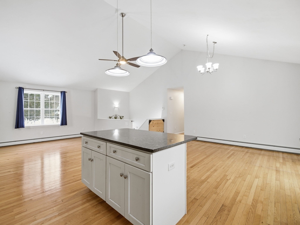 661 Wheelwright Road Barre, MA 01005 - Photo 14 of 42 a kitchen with stainless steel appliances granite countertop a sink a stove a dining table and chairs with wooden floor