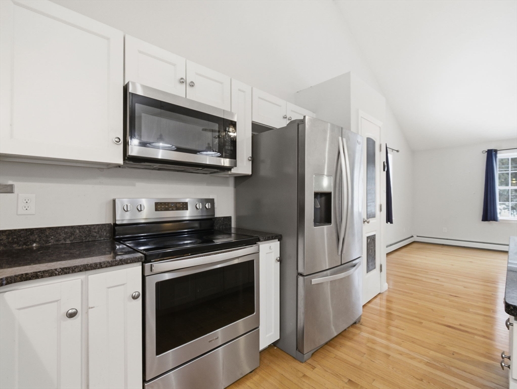 661 Wheelwright Road Barre, MA 01005 - Photo 15 of 42 a kitchen with stainless steel appliances a stove a microwave and a hard wood floor