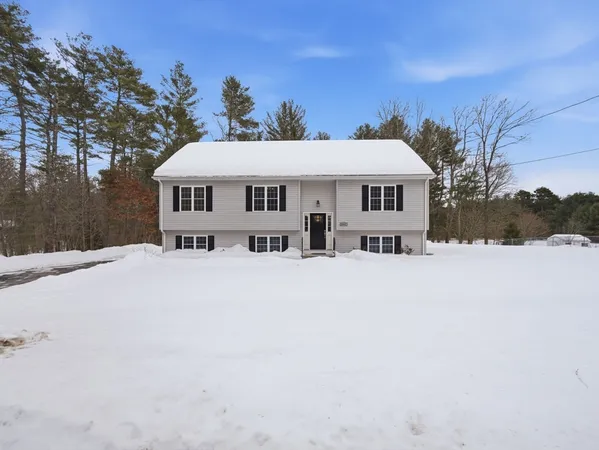 a front view of a house with a yard covered with snow