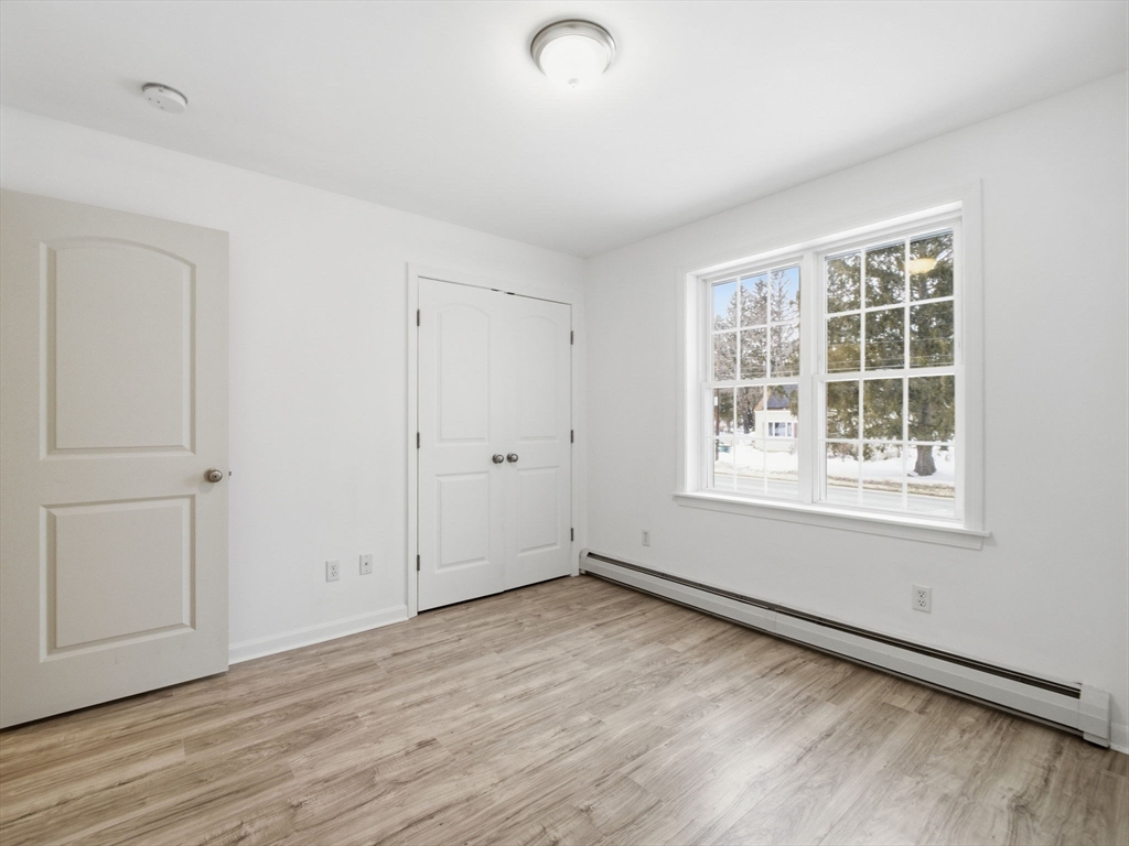 661 Wheelwright Road Barre, MA 01005 - Photo 21 of 42 an empty room with wooden floor and windows