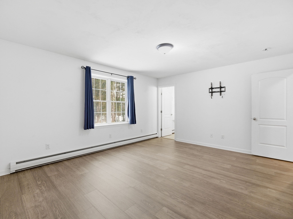 661 Wheelwright Road Barre, MA 01005 - Photo 27 of 42 an empty room with wooden floor and windows