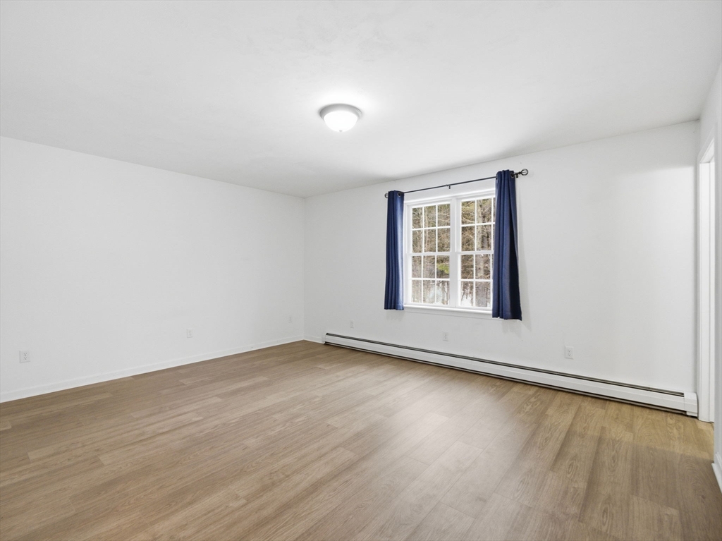 661 Wheelwright Road Barre, MA 01005 - Photo 28 of 42 an empty room with wooden floor and windows