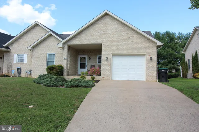 a view of a white house next to a yard and garage