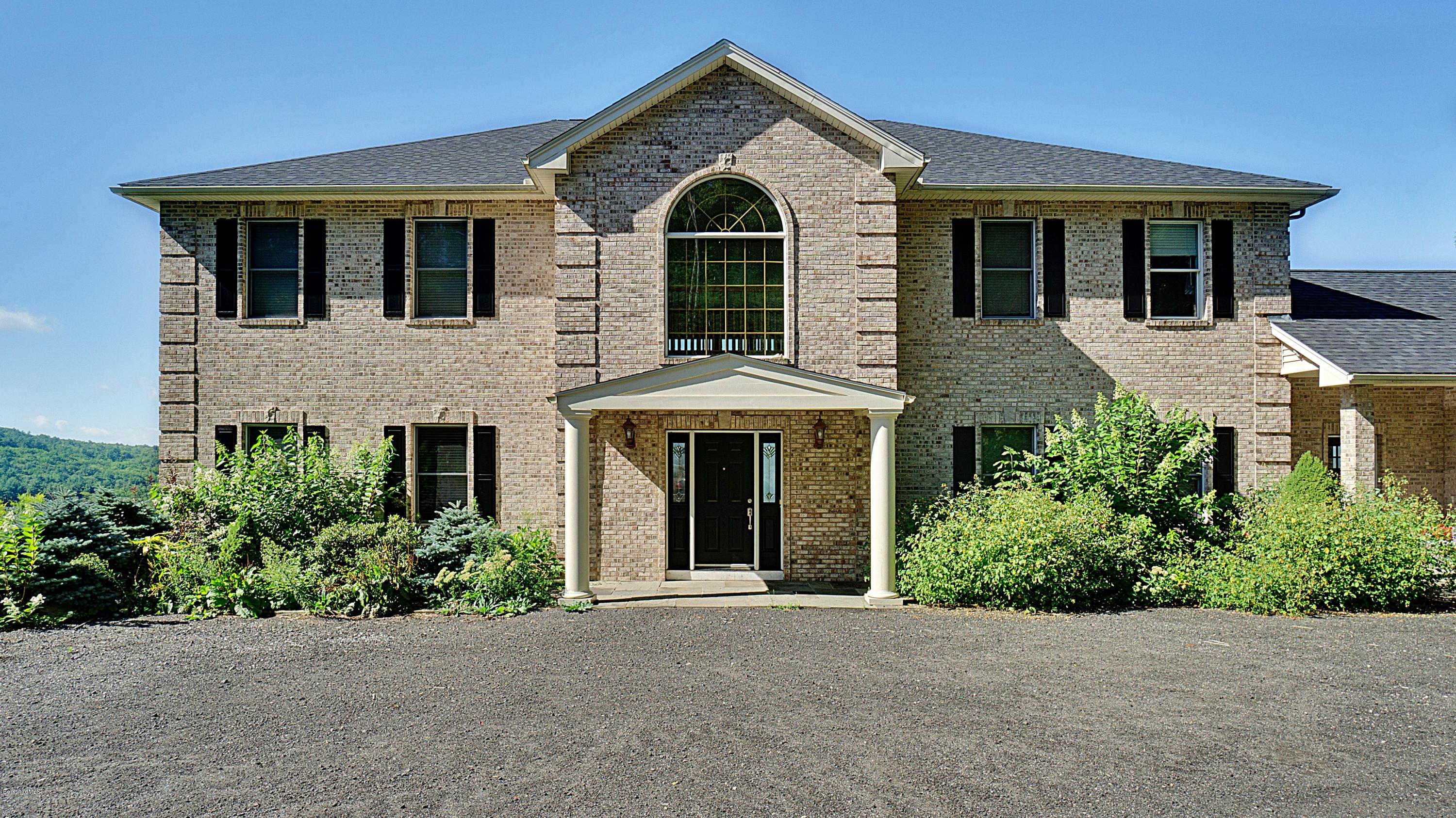 79 Hupi Road Monterey, MA 01245 - Photo 1 of 33 a front view of a house with a garden