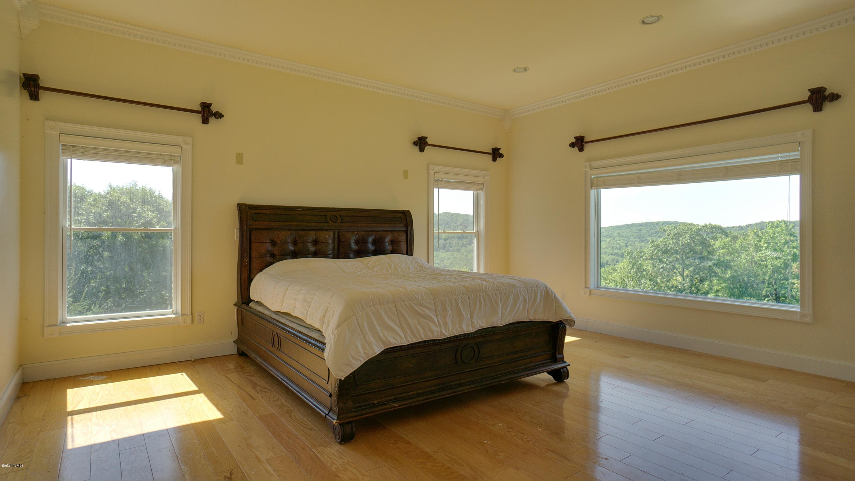 79 Hupi Road Monterey, MA 01245 - Photo 13 of 33 a bed sitting in a bedroom next to a window