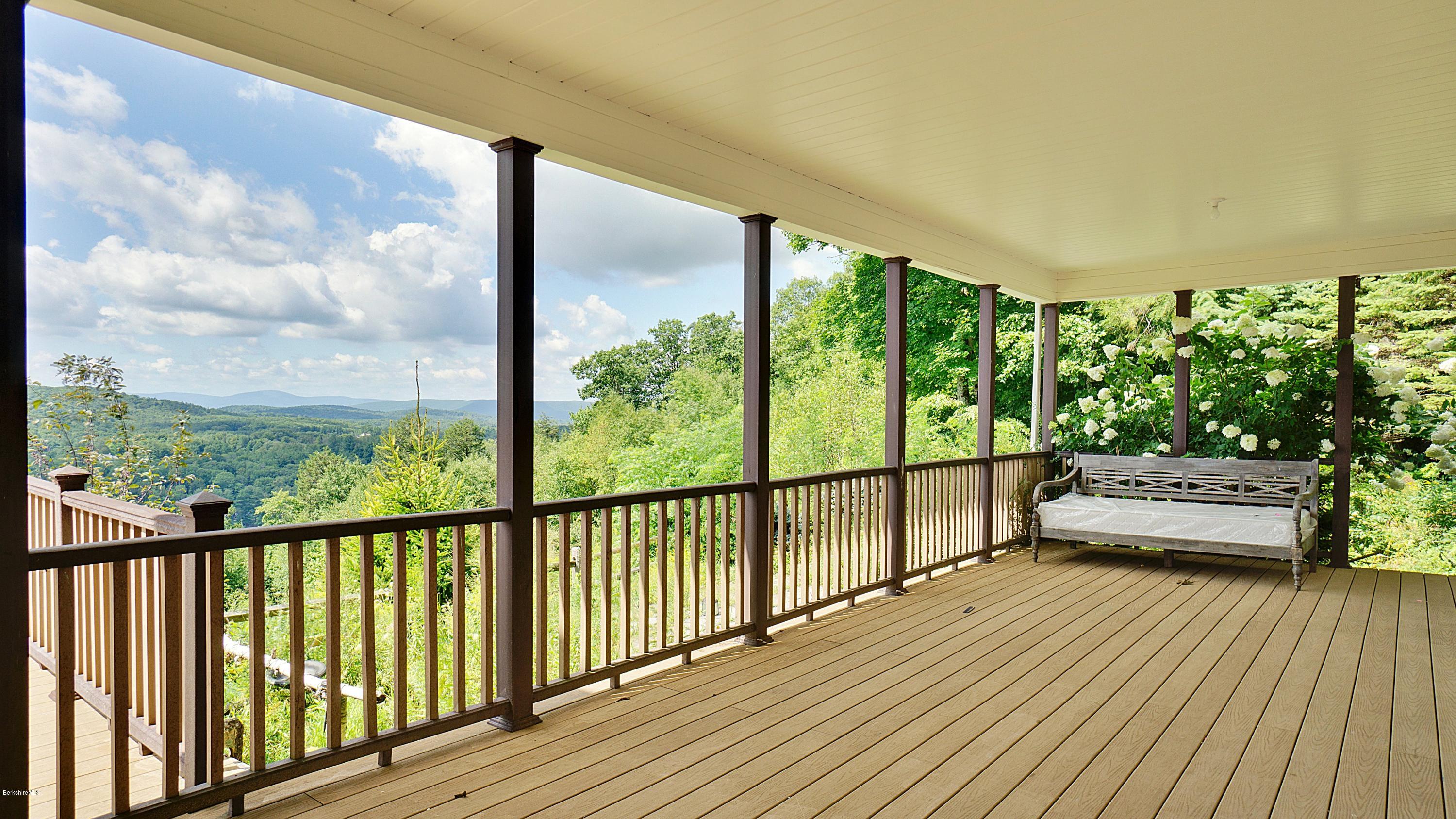 79 Hupi Road Monterey, MA 01245 - Photo 23 of 33 a view of a balcony with floor to ceiling windows with wooden floor
