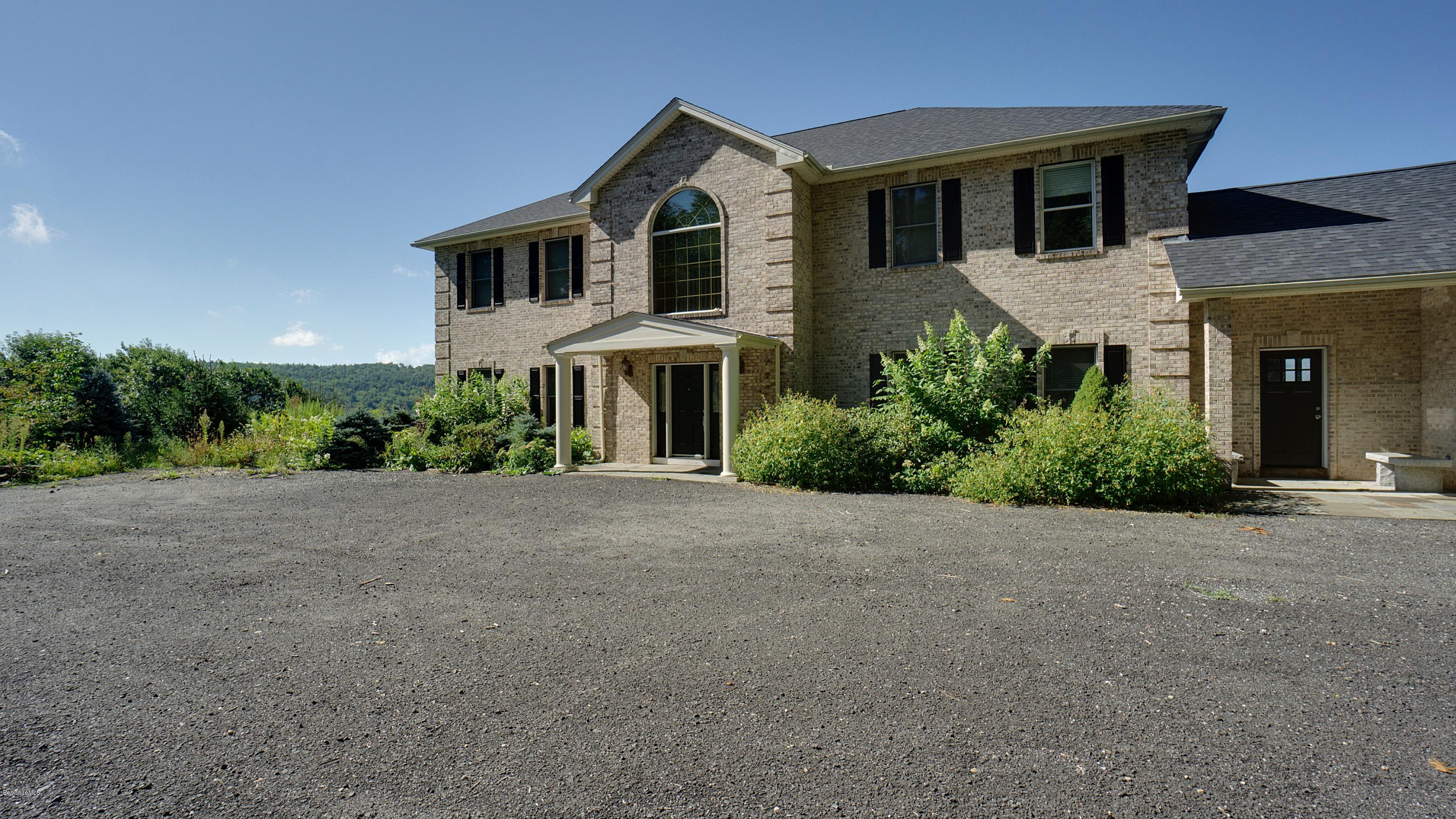 79 Hupi Road Monterey, MA 01245 - Photo 29 of 33 a front view of a house with a yard and garage