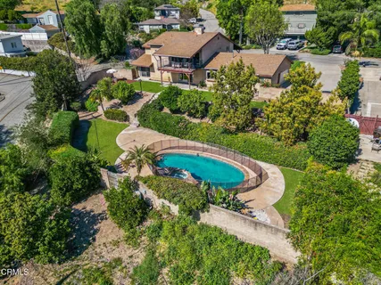 an aerial view of a house with a yard and lake