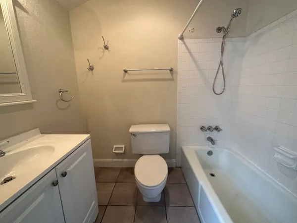 a bathroom with a toilet sink vanity and shower