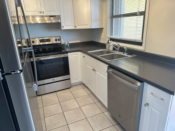 a kitchen with a sink a stove and cabinets