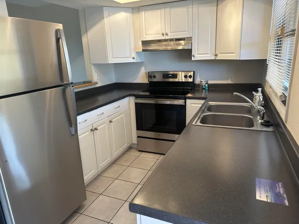 a kitchen with stainless steel appliances a refrigerator sink and cabinets