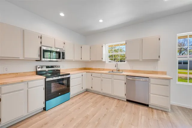 a kitchen with granite countertop cabinets stainless steel appliances and a sink